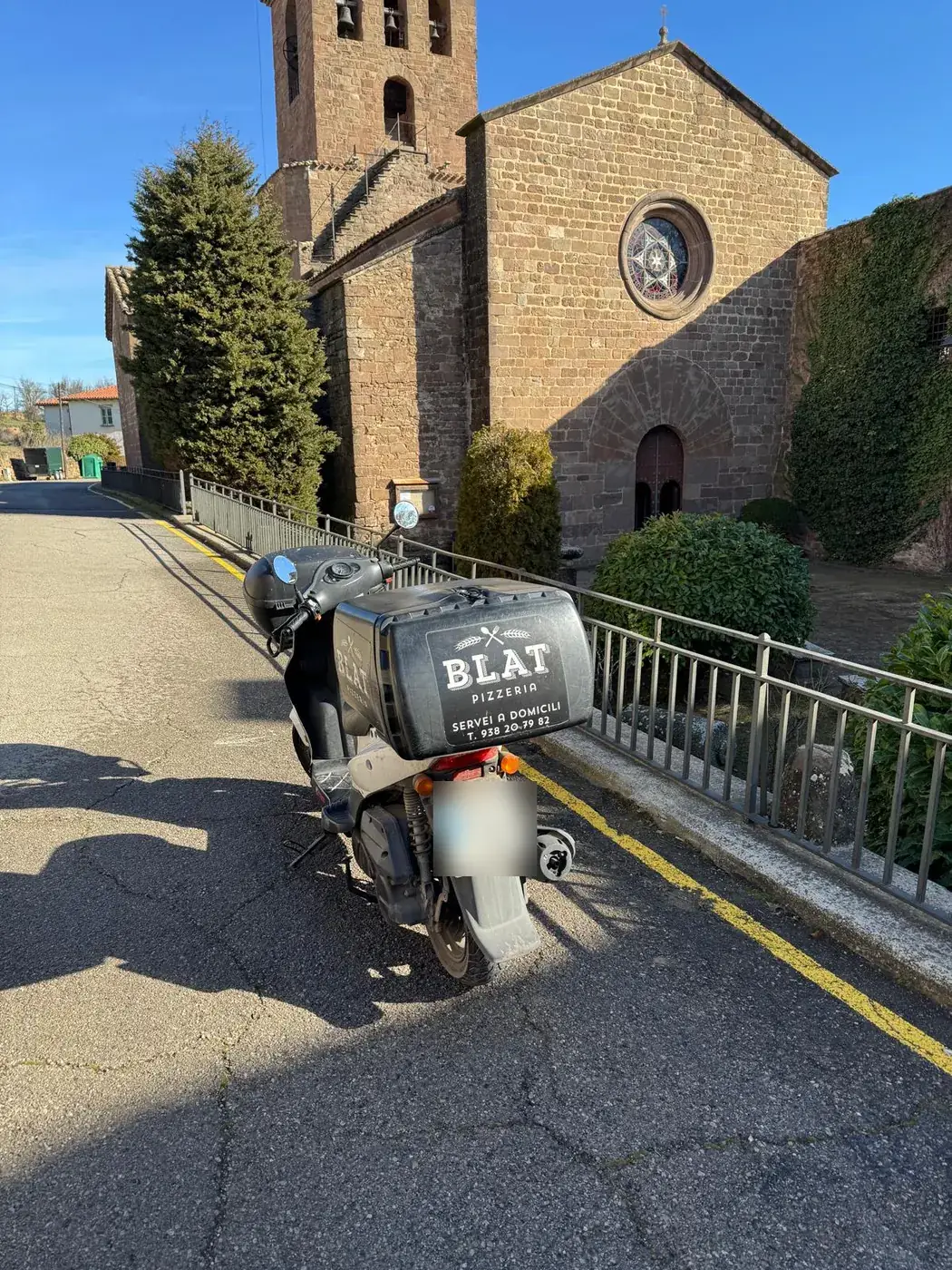 La moto de repartiment de Blat davant l'església de Moià